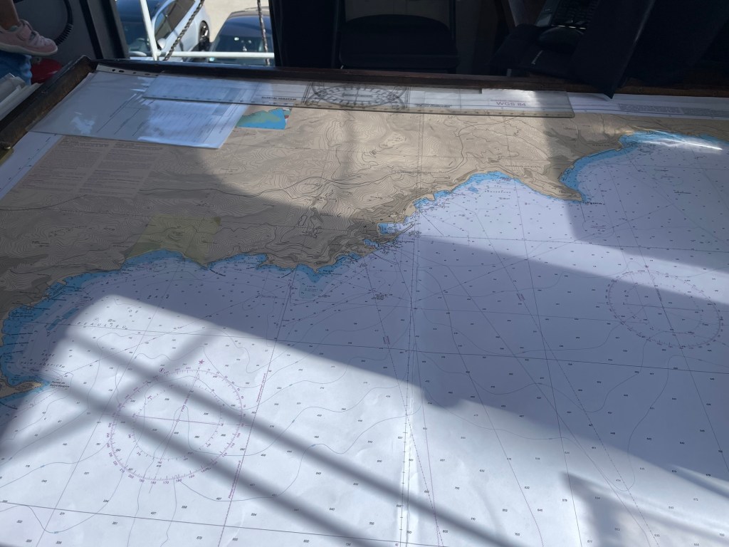 Sunbeams dapple a naval map of a coastline